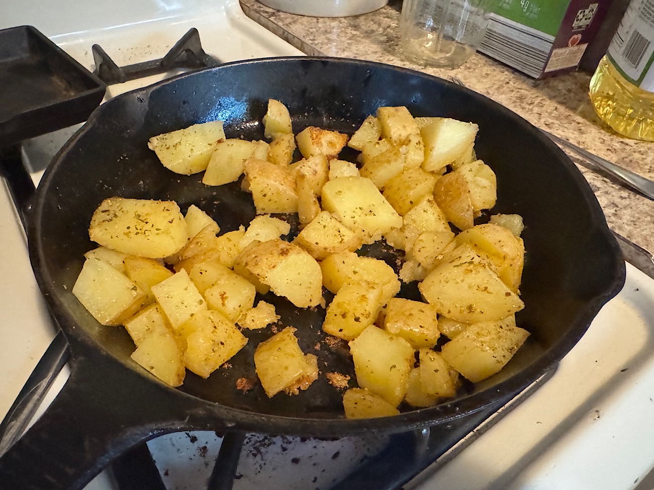 Cast iron skillet on the stove with potatoes