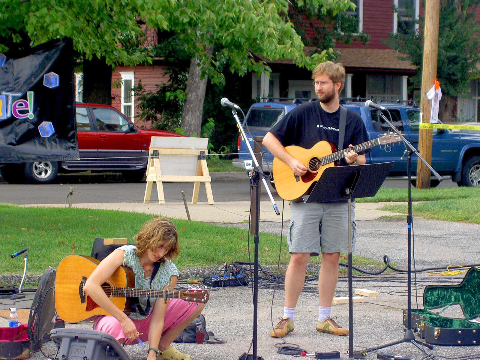 Don and Lori Chaffer, holding guitars outside on a sidewalk